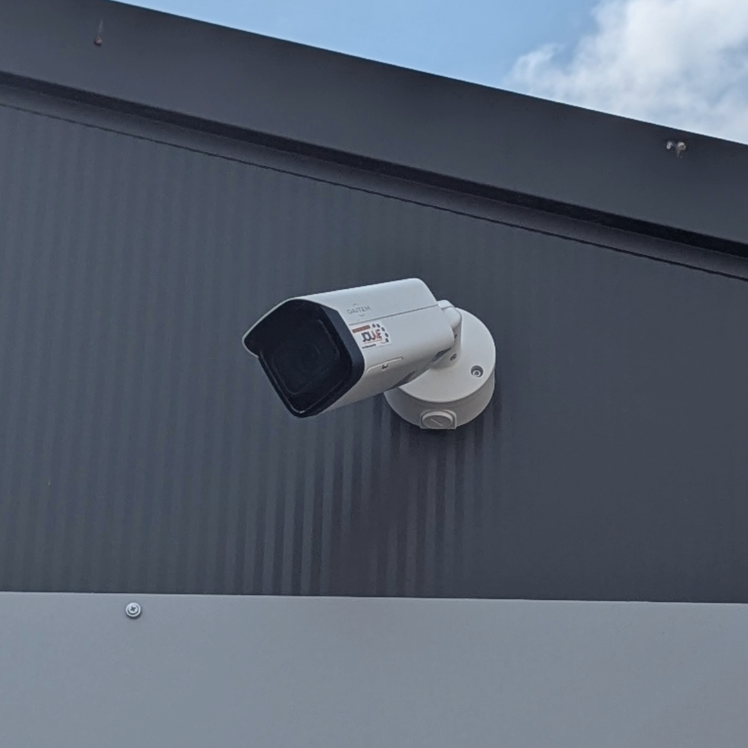 camera de surveillance extérieure pose murale sur mur gris