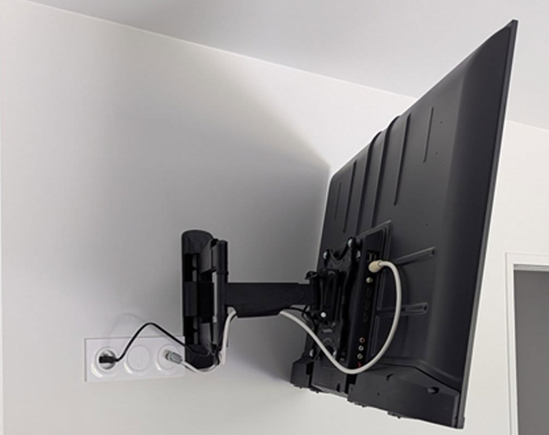TV écran plat sur support mural noir sur mur blanc