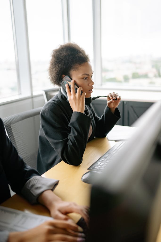 Une femme afro-américaine parle au téléphone portable dans un environnement de bureau moderne
